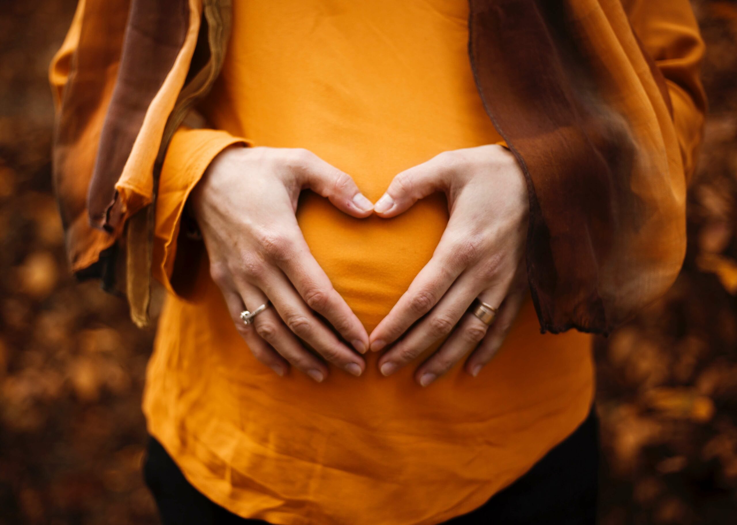 pregnant lady with hands in heart shape on belly