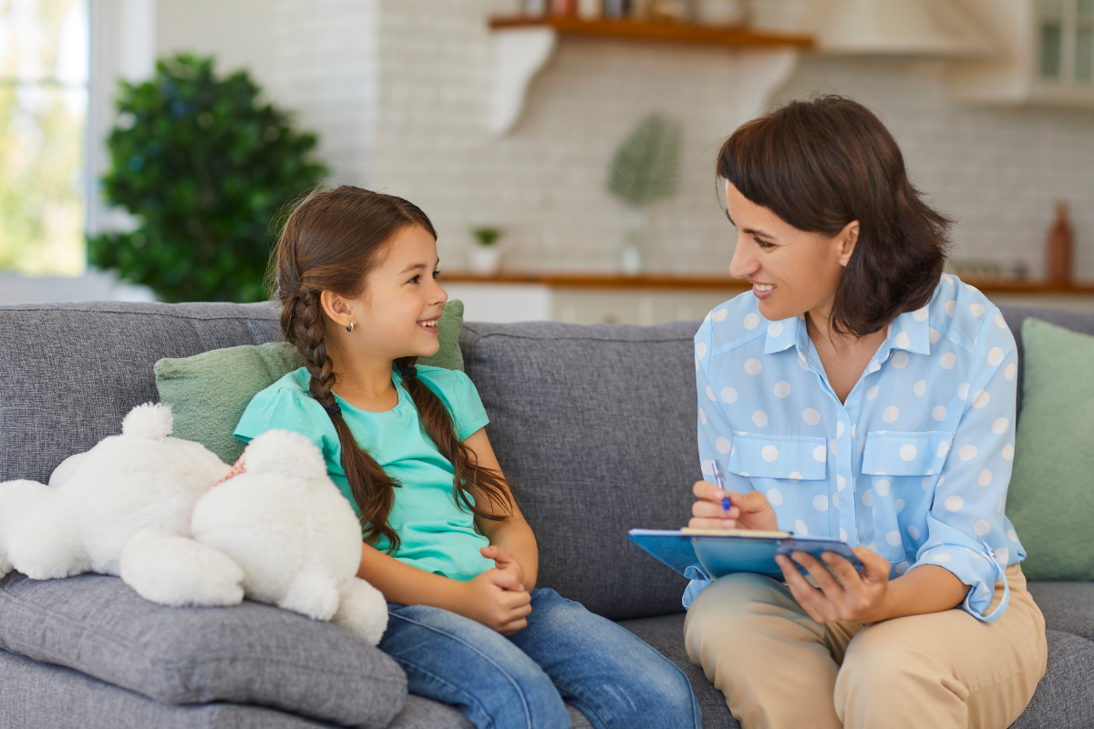 Child and adult sitting on couch talking